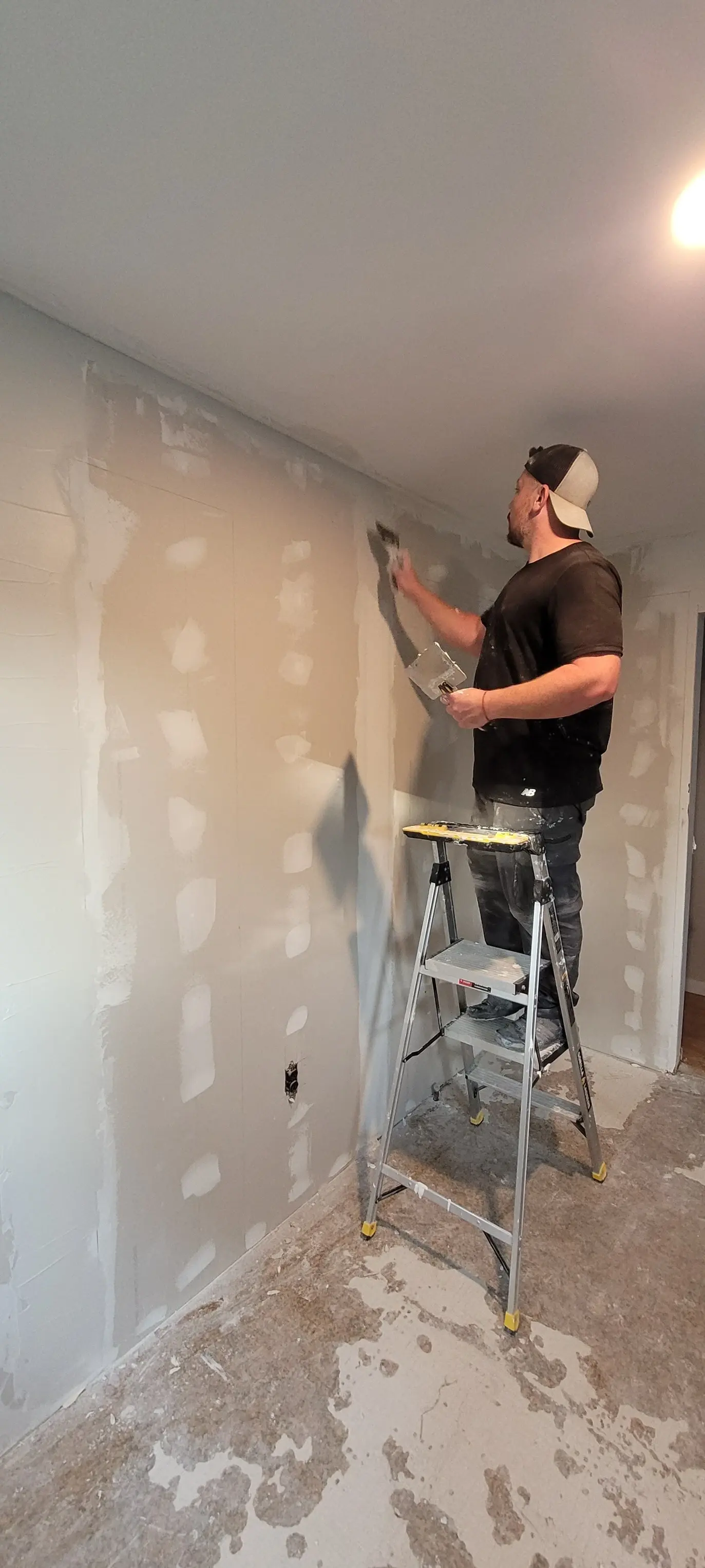Andre mudding a wall on a Great Choice Builders job site